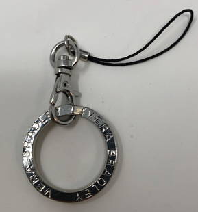 Vera Bradley Keychain: Description: Round, silver metal Vera Bradley keychain, inscribed with manufacturer's name on both sides. Material: metal. Measurement: approximate 2.50" (INCHES). Shipping: $10; different rate to