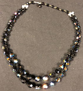 Beautiful Black Glass Beaded Necklace: Description: Black goes with everything! This glass beaded two strand necklace will add a little panache to any outfit; beads have a beautiful iridescent sheen. Adjustable closure. Material: glass;