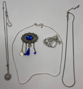 Sleek Silver tone Necklaces and Brooches: Description: Sleek and stylish collection of three silver tone necklaces and two ladies brooches, one enhanced with lovely deep blue glass stones and the other studded with clear crystals. Five piece