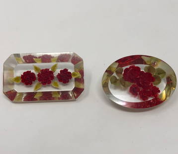 Mid-Century Lucite Rose Brooches: Description: Charming pair of mid century clear lucite rose themed brooches; most probably circa the 1950s. One brooch is oval, the other rectangular-shaped. Both feature an always in bloom, vivid