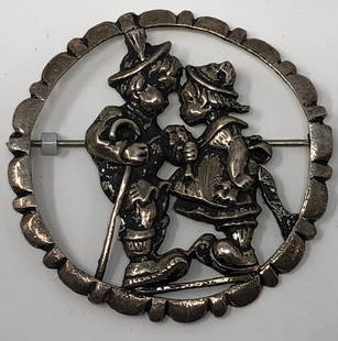 Charming Pewter Brooch: Description: Absolutely charming pewter brooch depicting two young children face to face, both wearing Swiss-themed attire. Set in a circular shape. Material: pewter. Measurement: approximate 2"