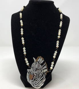 Striking Lee Sands Zebra Head Shell Necklace: Description: Striking Lee Sands pendant necklace, suspended from a white and black onyx beaded chain. The zebra head is crafted from pieces of multi-colored shell, set into a Lucite like backing.