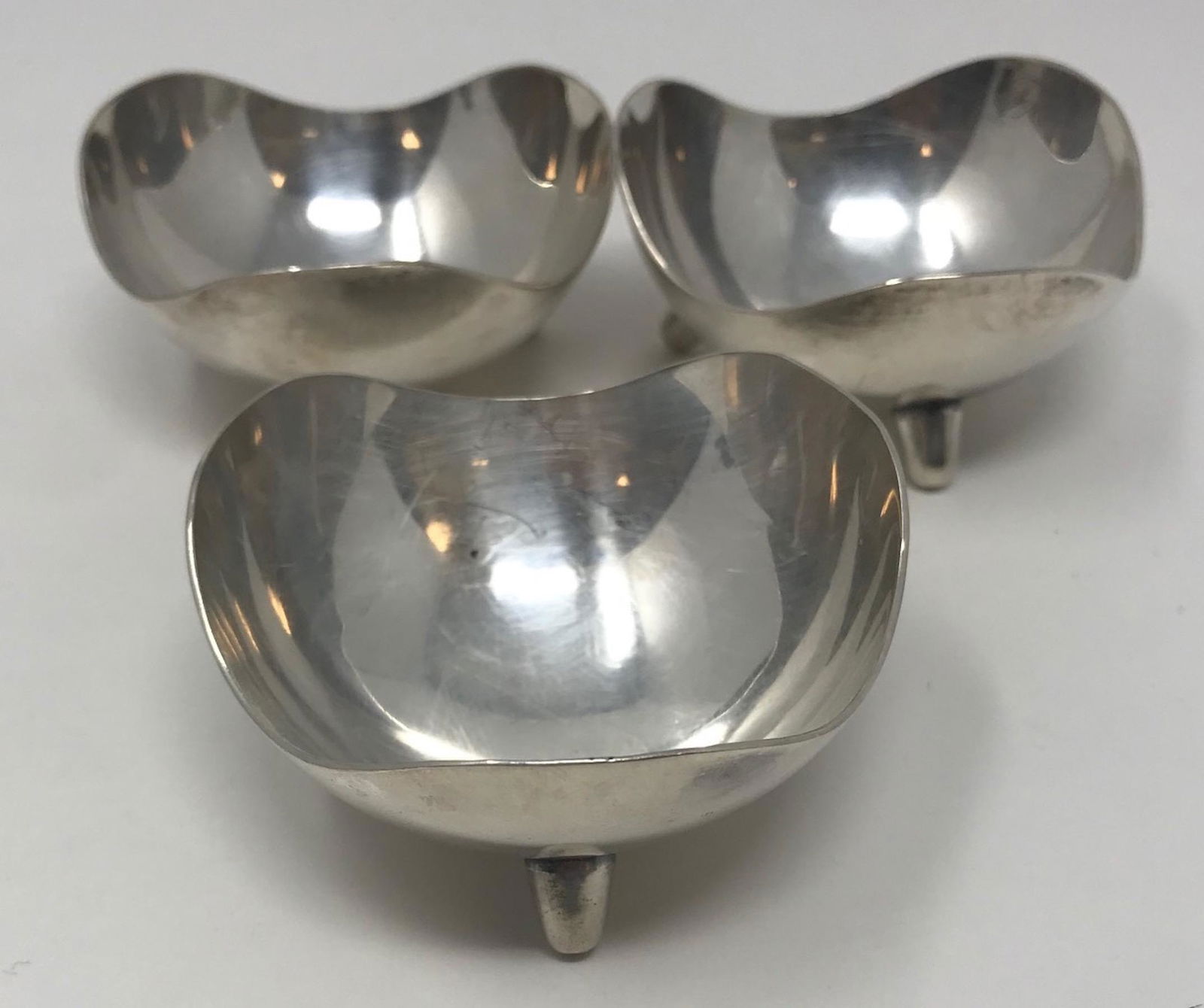 Set of 3 (three) gorgeous silver shell design three: Description: Set of 3 (three) gorgeous silver shell design three footed holders; Measurements: 2.75" x 2.75" each stamped MADE IN DENMARK; all measurements are approximate; Shipping cost: $35. Differe