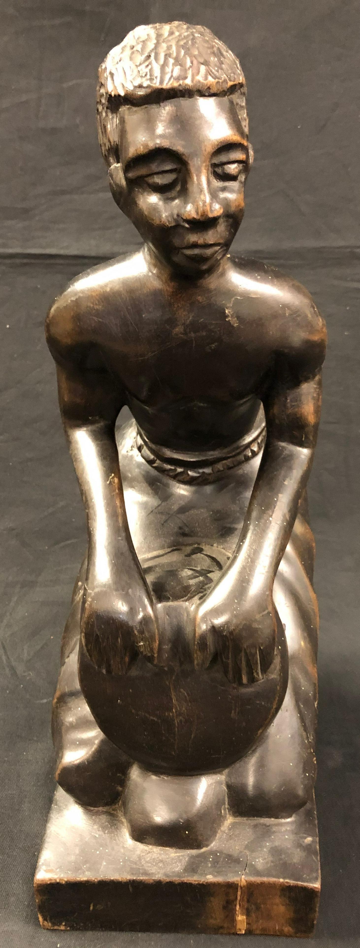 Vintage Signed Carved Wood Statue: Description: Signed wood statue, possibly Haitian or African in origin, signed R. Simeon. Hand carved from dense, dark wood, statue depicts a kneeling man playing a drum. Few age cracks in base; very