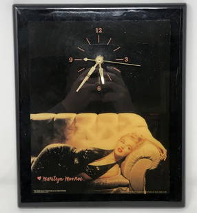 Marilyn Monroe wall CLOCK gold on black ON COUCH 2000: Marilyn Monroe wall CLOCK gold on black ON COUCH 2000 estate #MM103 , pink heart signature, battery operated, untestedApproximate measurements: 10 x 12 inches Materials: wood, metal, plastic,