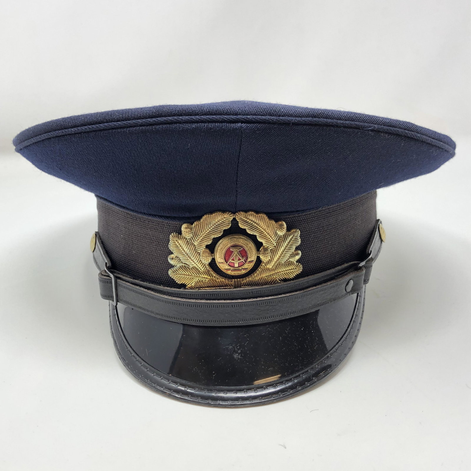 Vintage NVA 56 1856 D Military Police Hat W/ Visor: Vintage NVA 56 1856 D Military Police Hat W/ Visor Officer East Germany German APPROXIMATE MEASUREMENTS: 10 inches round x 5.5 inches MATERIALS: Fabric, leather, metal, plastique SHIPPING COST: $25. D