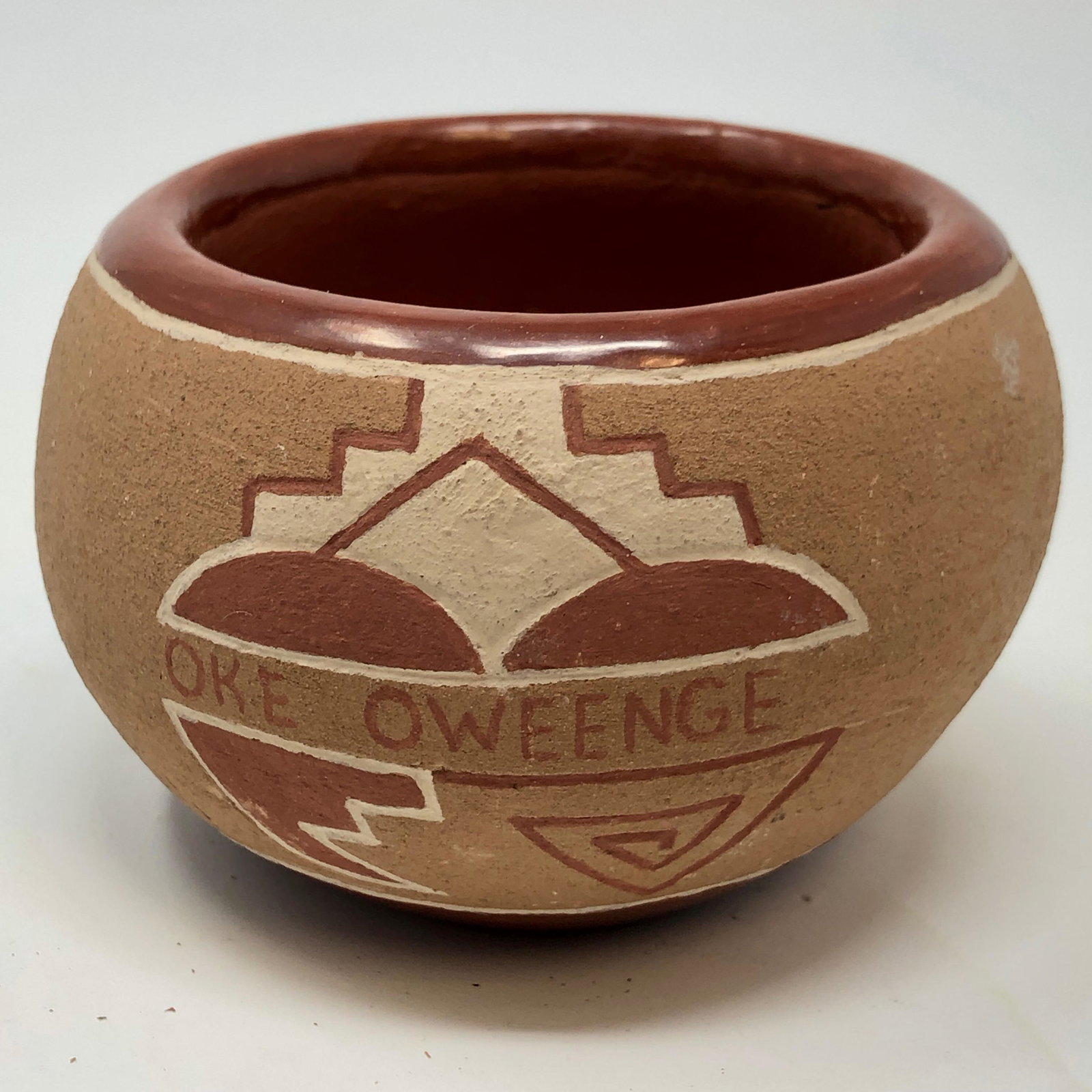 signed OKE OWEENGE handmade pottery with COA: Signed OKE OWEENGE handmade pottery with COA authenticationApproximate measurements: 3.5 x 2.5 inchesMaterials: clay, sand potteryShipping cost: $20. Different rate to California, Alaska, Hawaii and a