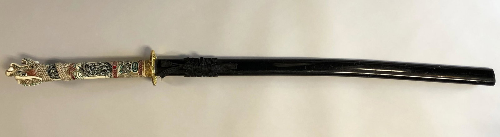 Katana Carved Dragon Head Sword: Katana Carved Dragon Head Sword. With sheath. Note: missing bottom cap from sheath. Blade: maker mark and stamped CARBON STEEL HANDCRAFTED IN CHINA. Approximate measurements: 43 inches total length in