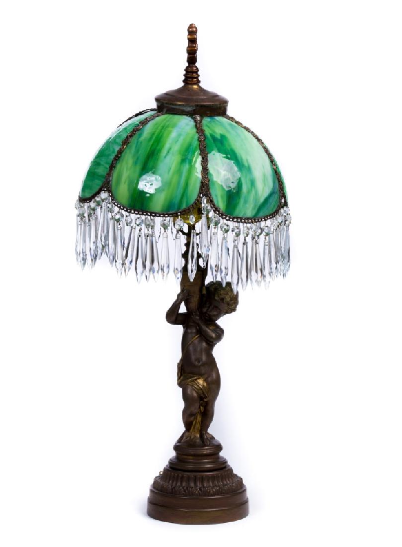 FRENCH METAL SLAG GLASS LAMP: French metal slag glass lamp. Has a boy on the lamp. Green shade and crystal droplets. Measures approx.30"h x 12" d.