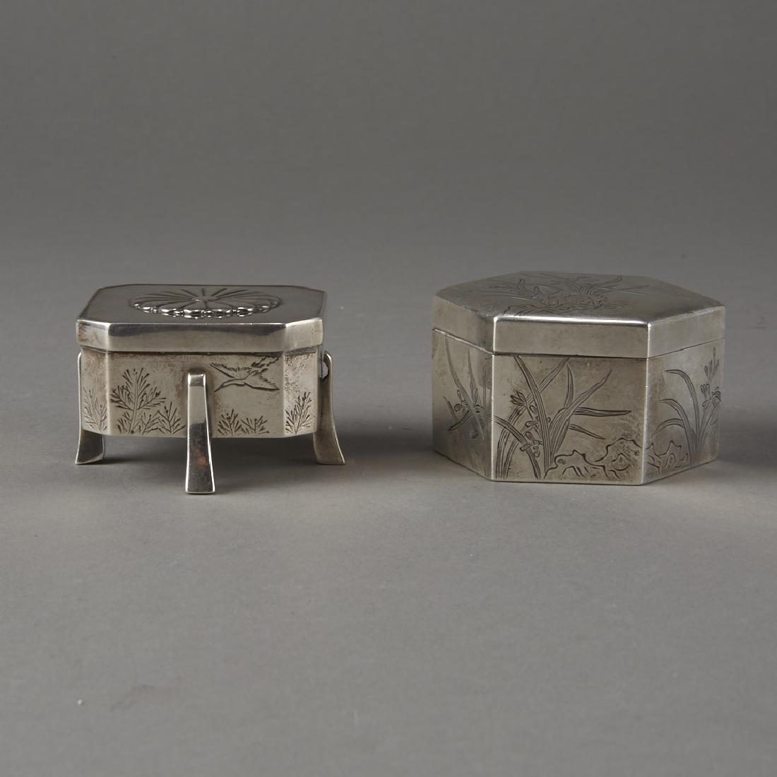 Japanese 20th C. Silver Boxes Decoration: Two silver boxes: the first is hexagonal in shape with a river scene of lillies and rocks incised on the cover and outside walls. The second box is octagonal in shape and stands on four legs with flyi