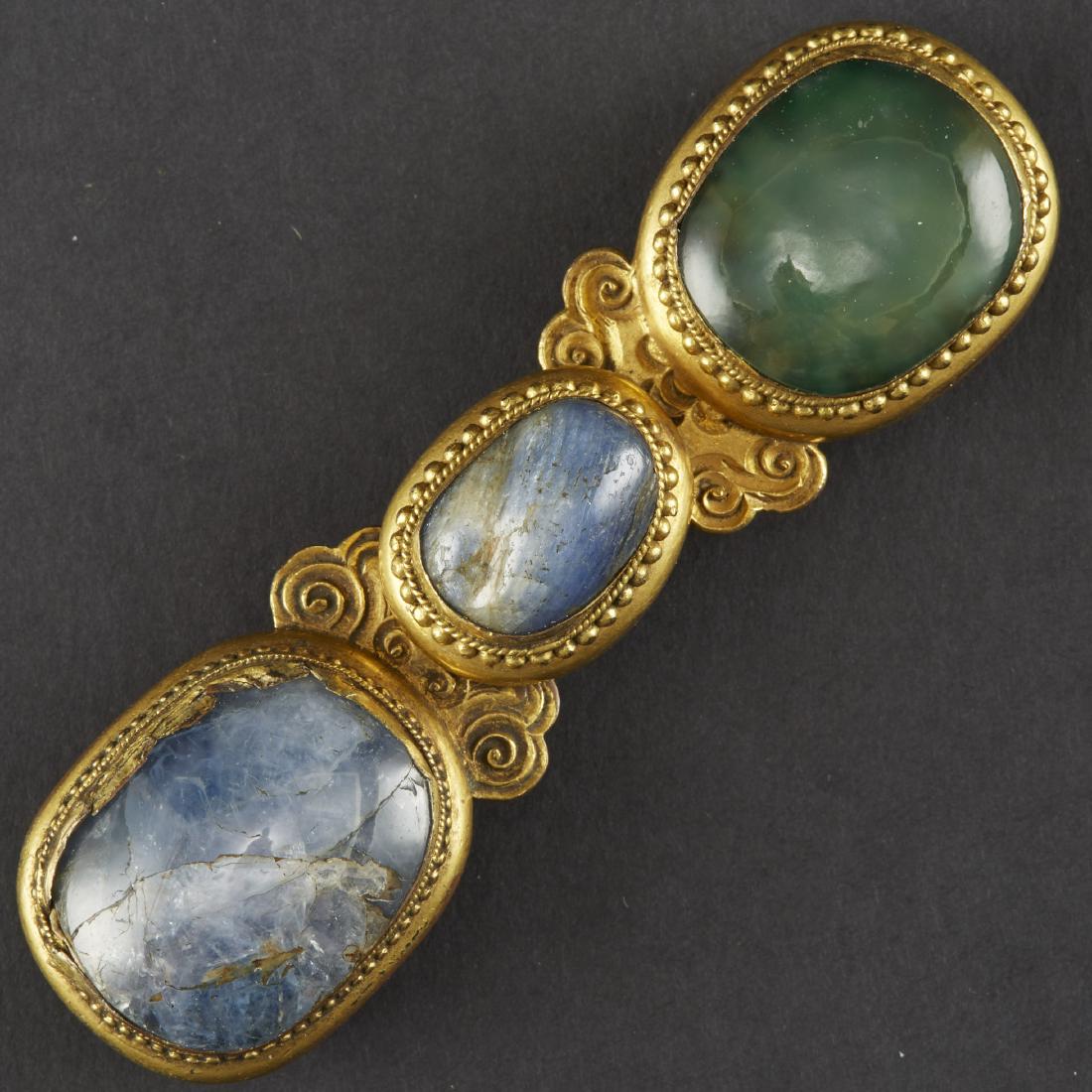 Chinese Gilt Bronze Sapphire and Glass Buckle - 18th: Fine 18th century Chinese buckle, made of gilt bronze, sapphire, and glass. Each cabochon is set with in roped and pearled border with scrolling motifs along the center stone.Height: 1 in x width 4 in
