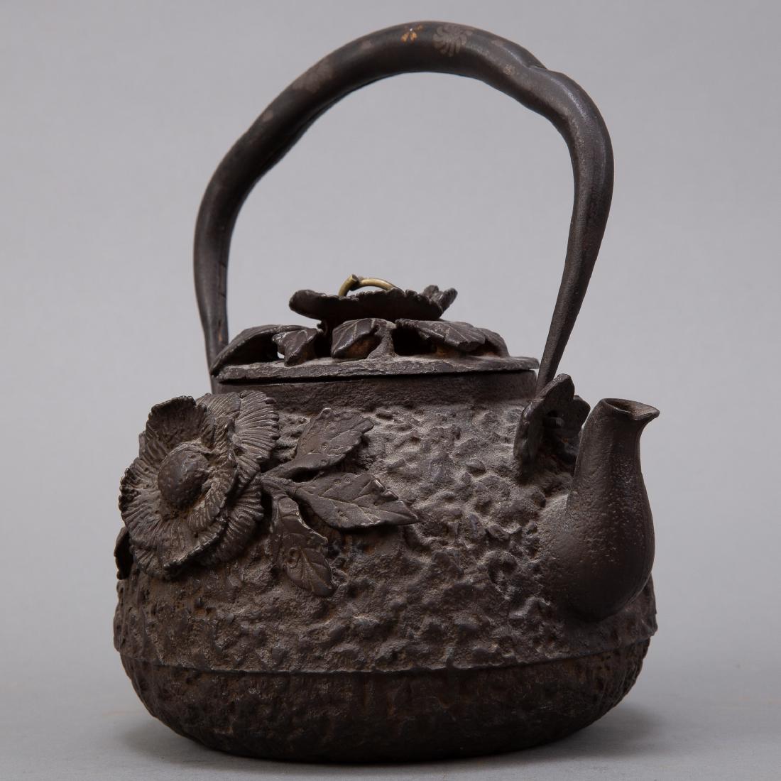 Japanese Meiji Iron Kettle with Silver and Gold: A lovely well made iron teapot decorated with applied flowers. Inlay in handle. Dimensions: Height (including handle): 9 in x width: 7 in x depth: 5 in. SKU: 00961