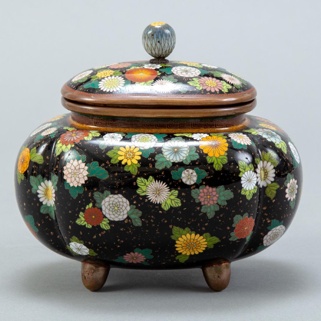 Japanese Meiji Cloisonne Covered Urn: An exquisite example of Meiji Japanese cloisonne exhibiting floral designs on a black background. The work reflects the styles of workshops and artists such as Ando Jubei, Hayashi Kodenji, and Namikaw