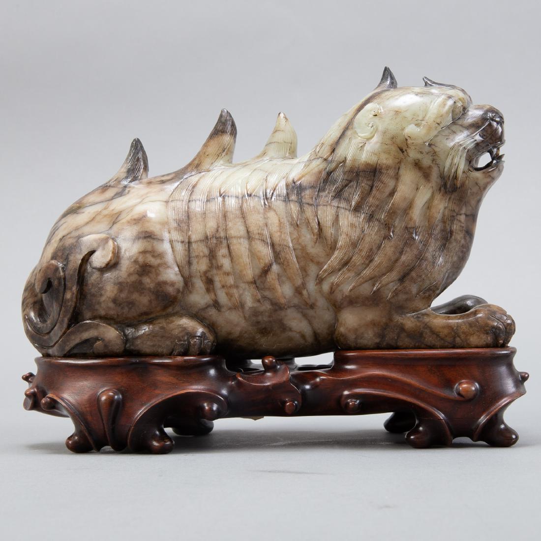 Chinese Large Jade Foo Dog/Lion: A large Chinese grey jade carving of a foo dog, well carved of a mottled grey stone. On a well carved Chinese wooden stand. Provenance: Manheim Galleries, New Orleans, Louisiana, purchased 1973; Priva