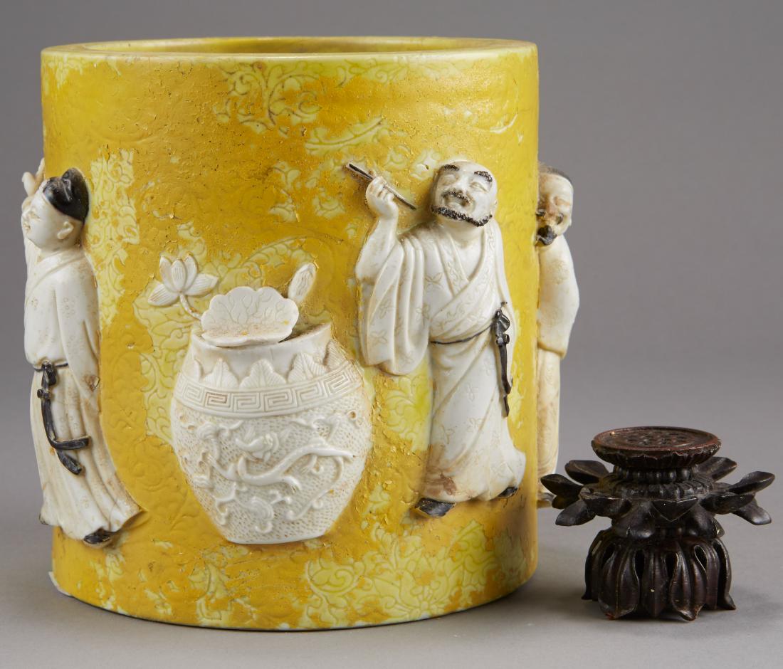Yellow Chinese Republic Brush Pot and Wooden Stan: Chinese Republic Period porcelain brush pot and wooden stand. Brush pot is yellow glazed with incised designs and applied figures pointing to the sun. Wang Bingrong Zuo mark along the underside. Stand