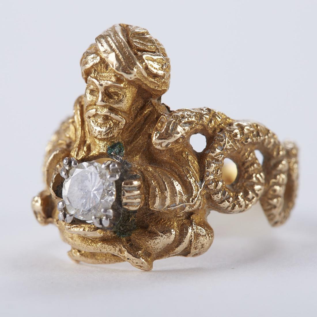 Diamond Ring with Man and Snake: 14K gold ring modeled as a snake and a man with a turban. The man holds the diamond. Marked "14K" along the inside of the band. Dimensions: Size 7. SKU: 01084
