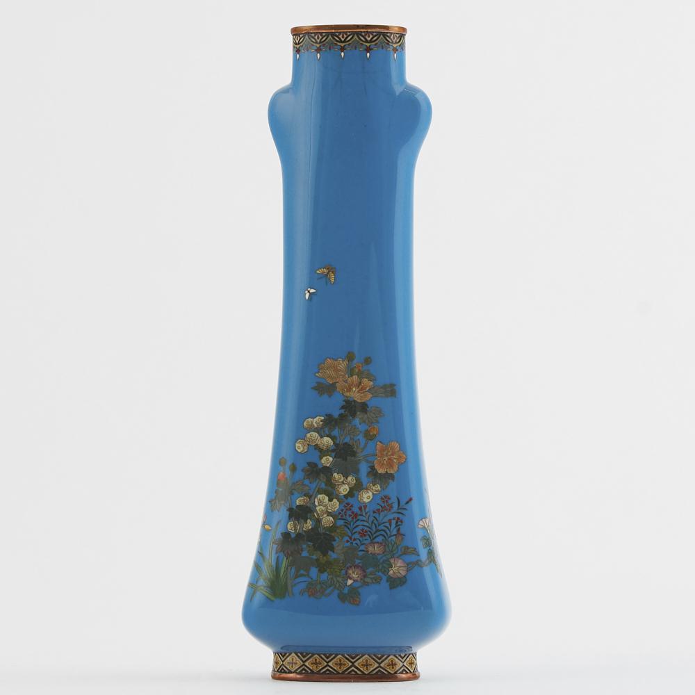 Meiji Japanese Cloisonne Vase Tsukamoto Hikokichi: Japanese Meiji period cloisonne vase by Tsukamoto Hikokichi. This vase features a delicate floral design with butterflies on a blue background. Marked under the base. Dimensions: Height: 10 in x width
