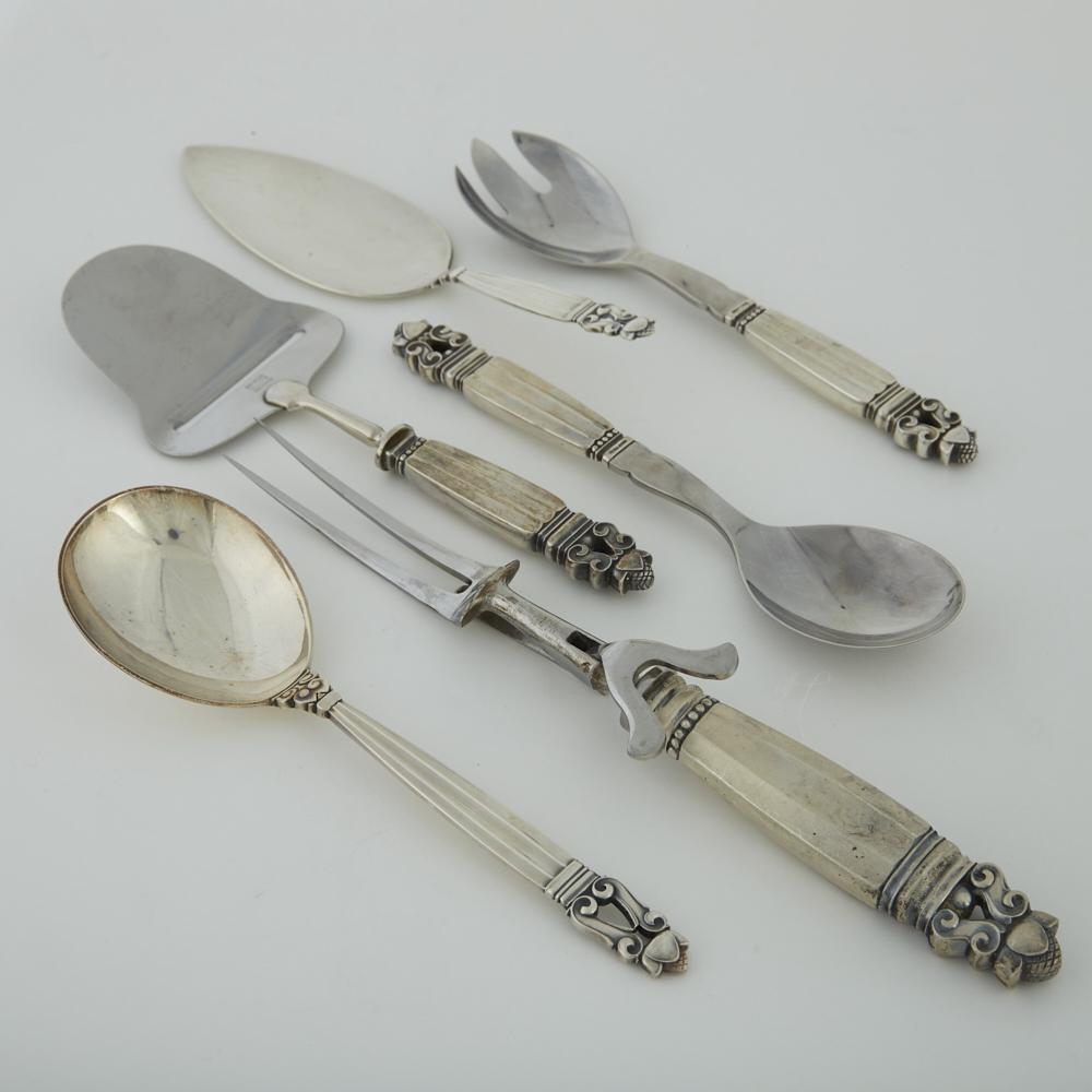6 Georg Jensen Serving Pieces: Group of six Georg Jensen sterling silver serving implements, including one cheese slicer, one pie server, one serving spoon, one salad fork, one salad spoon, and one large two-pronged fork. SKU: 0240