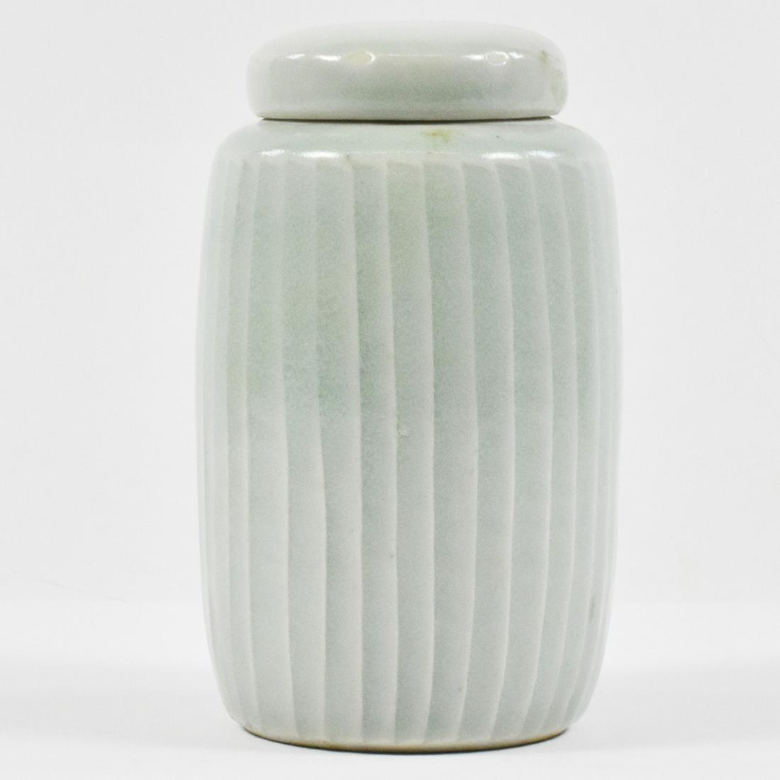 David Leach Celadon Ribbed Lidded Vase: David Leach (1911-2005). Ribbed porcelain vase with celadon glaze from the shoulder down. Marked with Leach's two seal marks along the footrim. Dimensions: Height: 5 in x diameter: 3 in. SKU: 03727