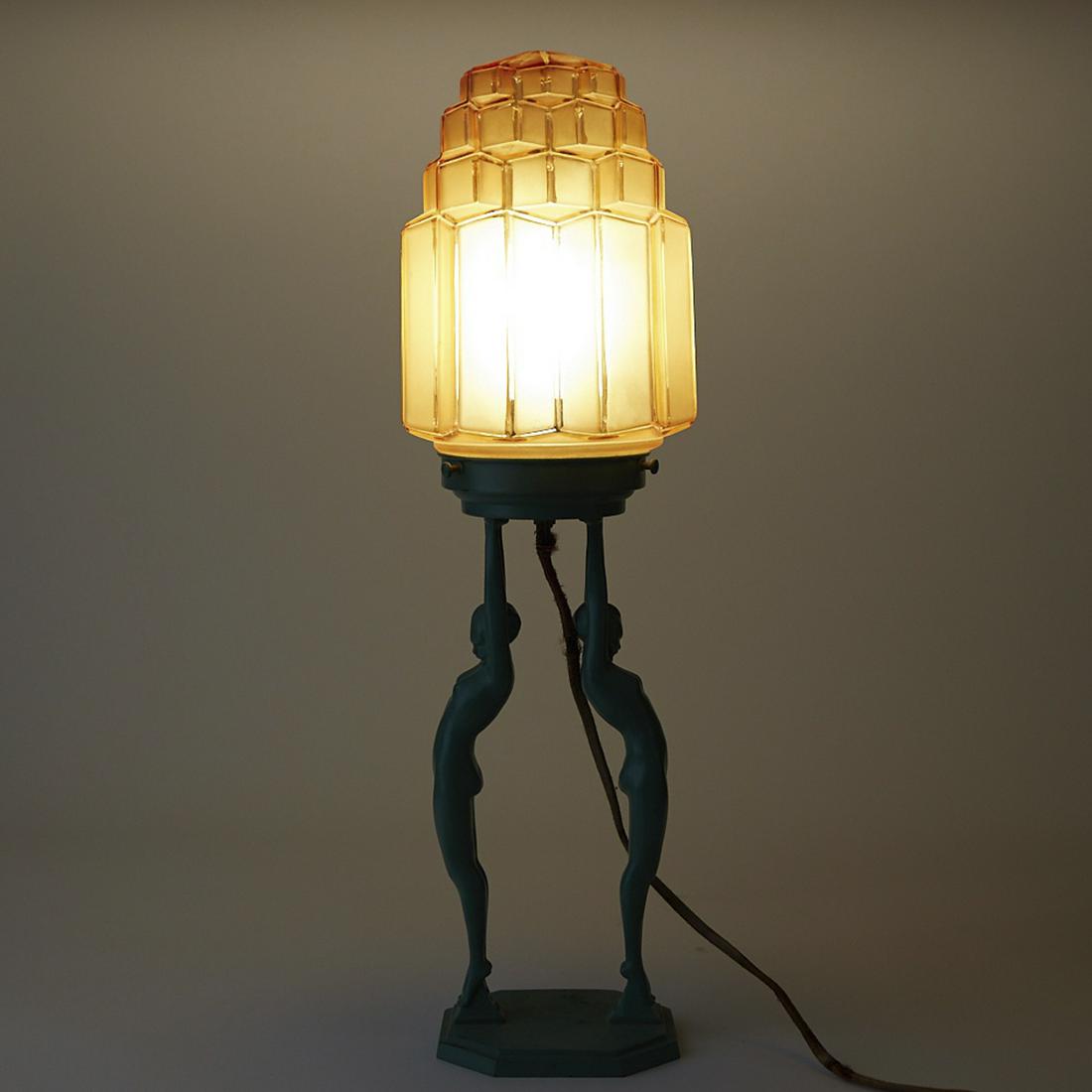 Art Deco Lamp with Blue Figures Frankart: Frankart Art Deco lamp. Faceted and stepped amber colored frosted glass shade with blue metal base in the form of two nude female figures holding the shade. Marked under the figures' feet "Pat. D 7720