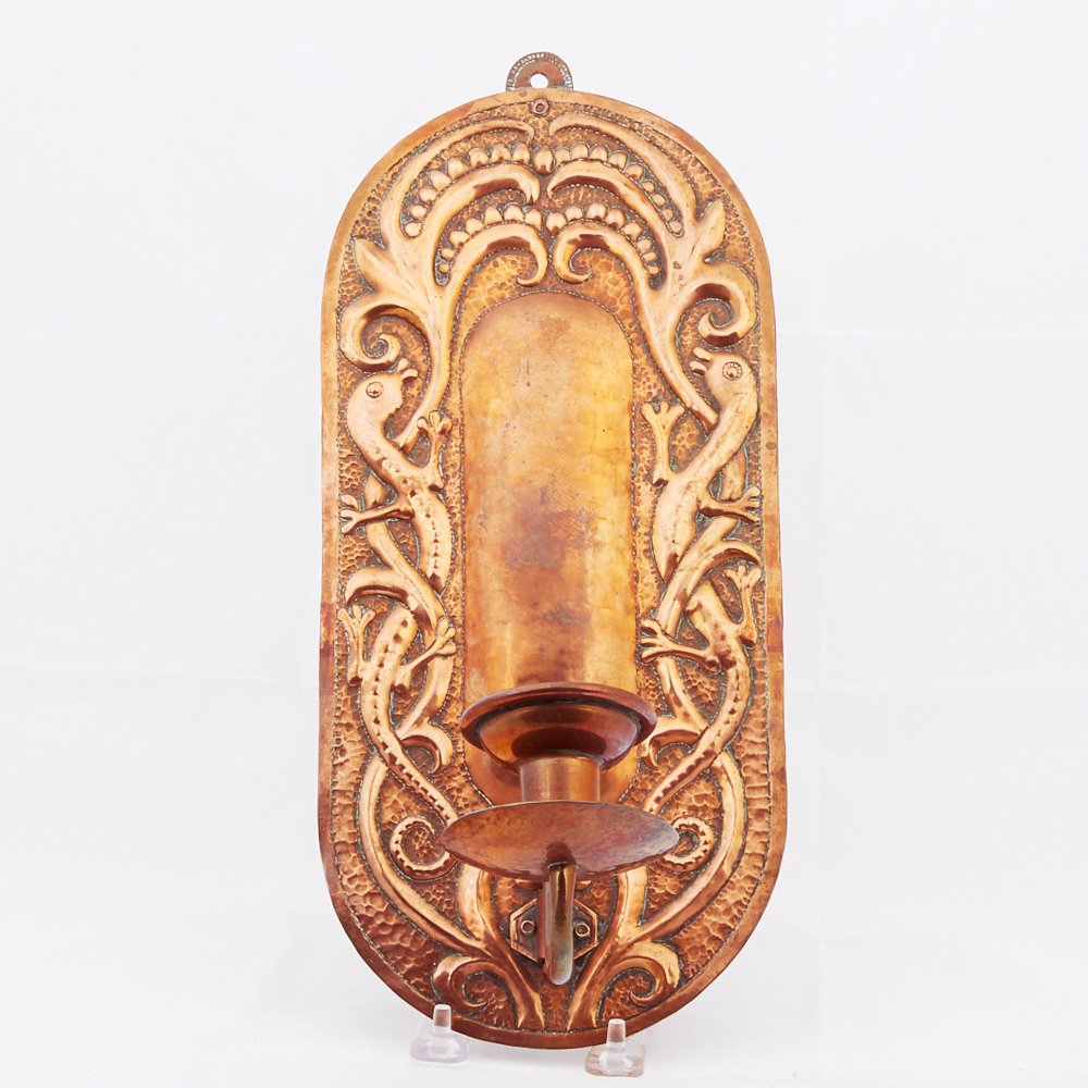 John Pearson Copper Sconce: John Pearson (active ca. 1885-1910). Hammered copper sconce candleholder with relief decoration featuring scrolling designs and salamanders. Signed J.P. and dated 1898 along the reverse. John Pearson