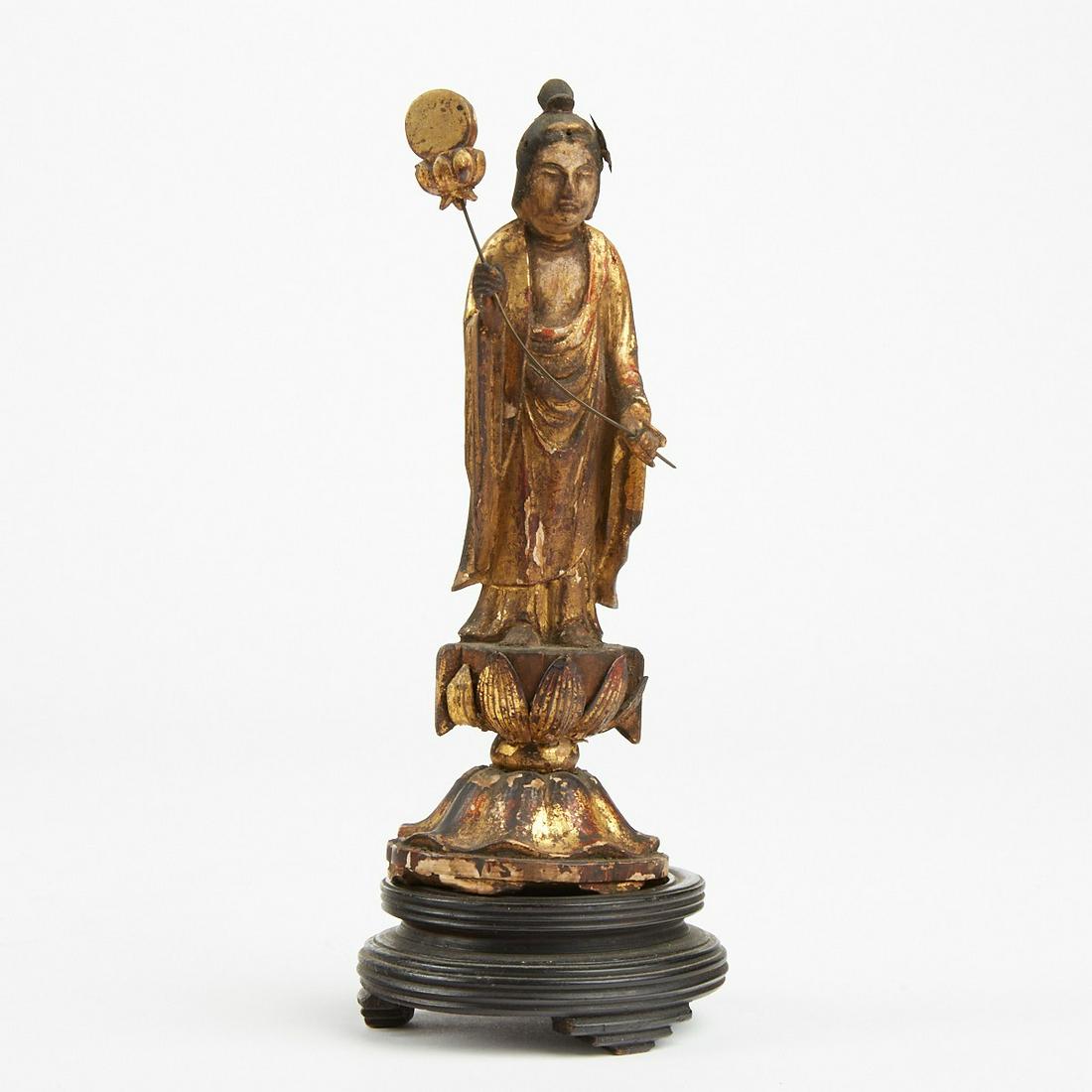 Edo Period Japanese Gilt Lacquered Buddha w/ Leaf: Japanese Edo period gilt and lacquered wooden Buddha figure gracefully holding a leaf. On wooden stand with glass bell cover. Figure (without stand); height: 7 in x width: 2 1/2 in x depth: 2 in.