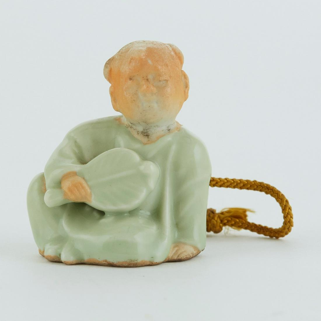 Japanese Meiji Hirado Porcelain Netsuke of a Child: Japanese Meiji period Hirado porcelain netsuke in the form of a child holding a fan. Height: 1 3/4 in x 1 1/2 in width: x depth: 1 1/2 in.