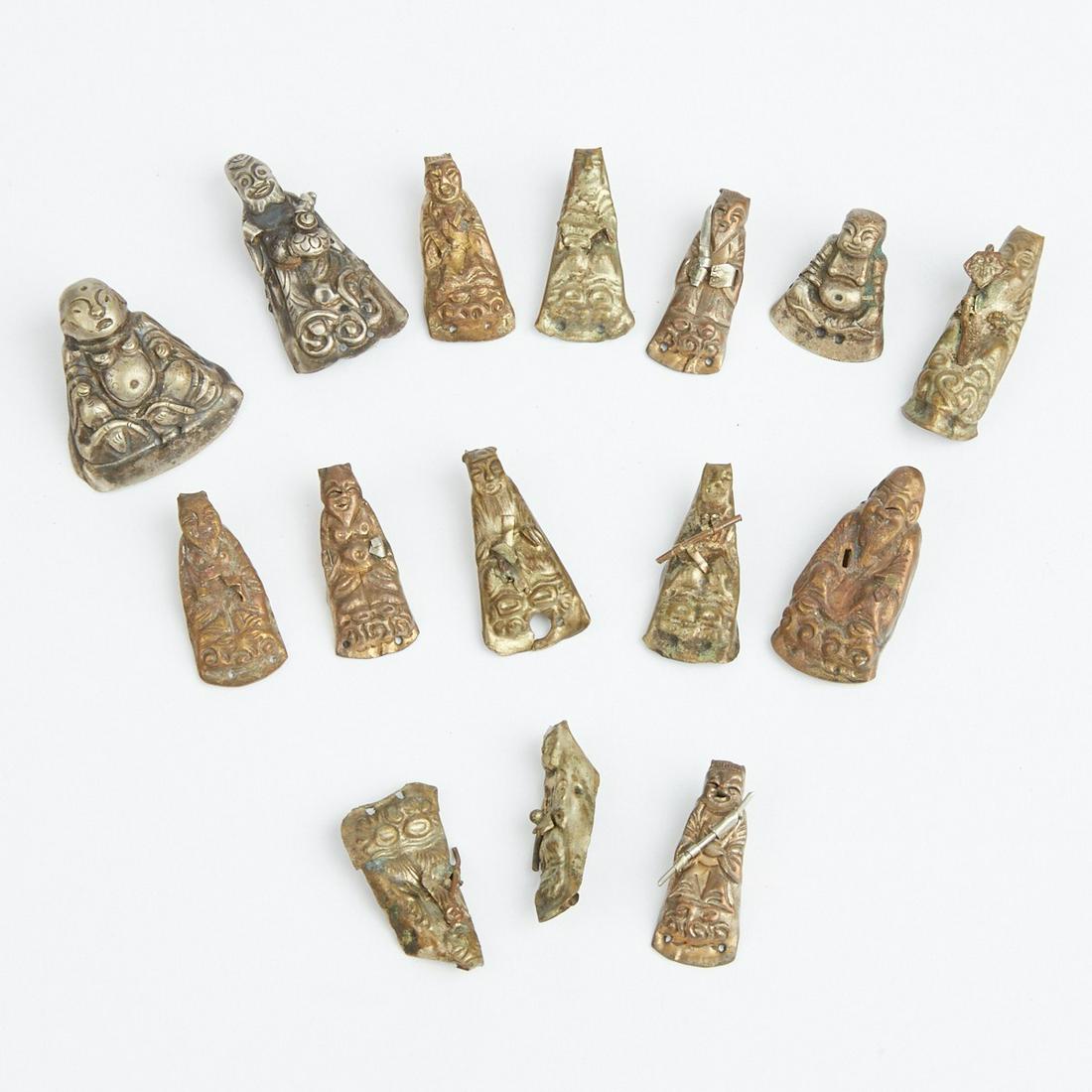 Grp: 15 Silver Buddha Hat Decorations Figures: Group of fifteen silver Buddha figure hat decorations. These finely detailed figures depict the Buddha in a variety of postures.Height: 1 1/4 in x width: 1 1/4 in x depth: 1/2 in.