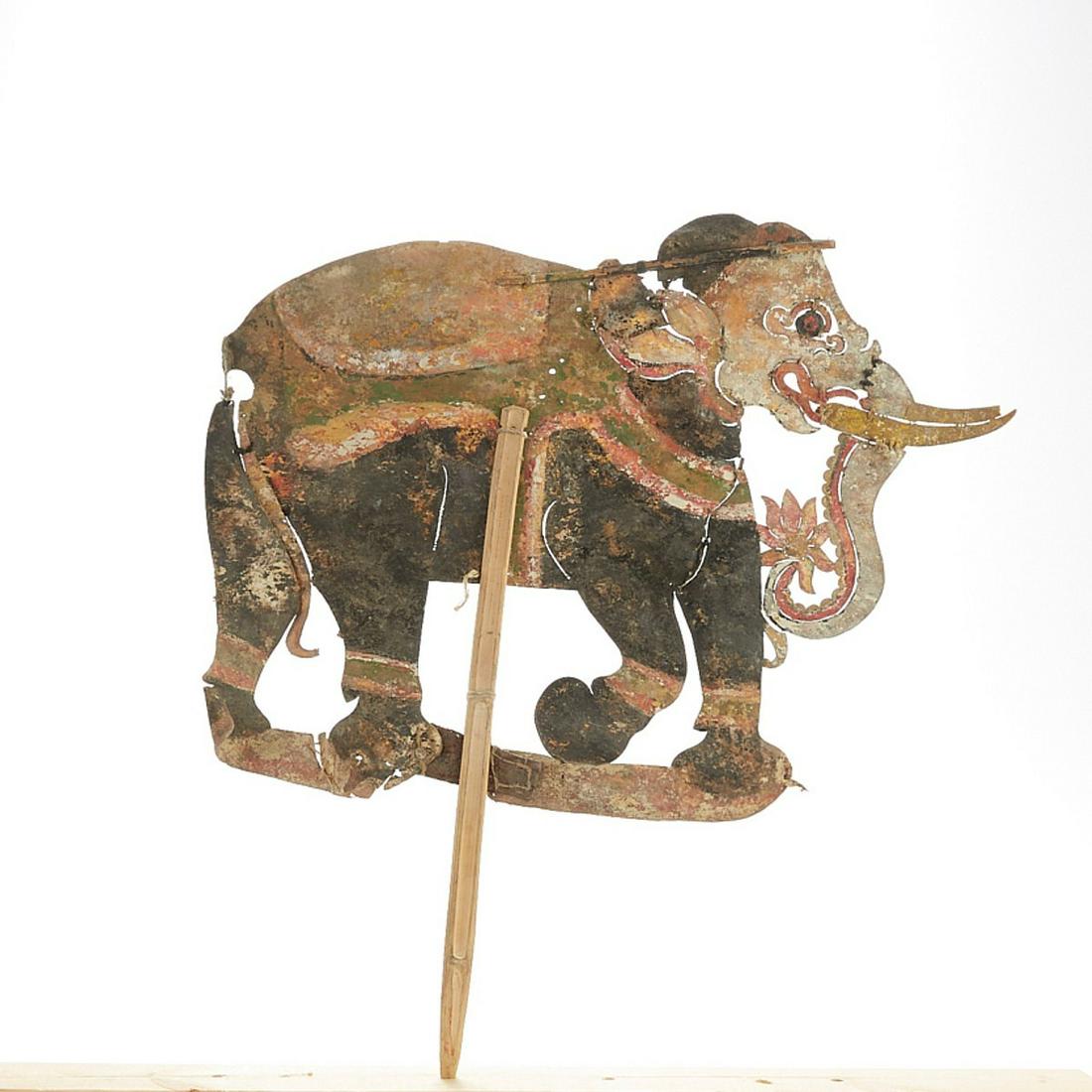 19th/20th c. Indonesian (Bali) Elephant Shadow Puppet: 19th/20th century Indonesian (Balinese) shadow puppet of an elephant. Polychrome leather with wooden control rod. Keyword: Wayang kulit Asia Height: 24 in x width: 21 in.