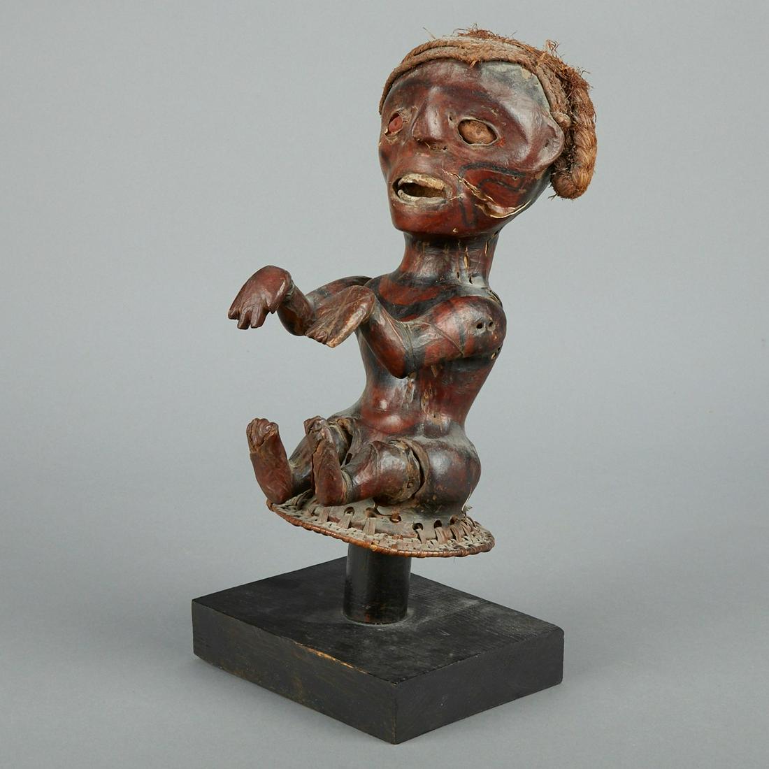 African Ekoi Skin Covered Headdress: Ekoi (Ejagham) skin covered figure or headdress Cross River region Nigeria and Cameroon. Carved wood sculpture of a seated figure with arms extended covered in skin which is decorated with dark painte