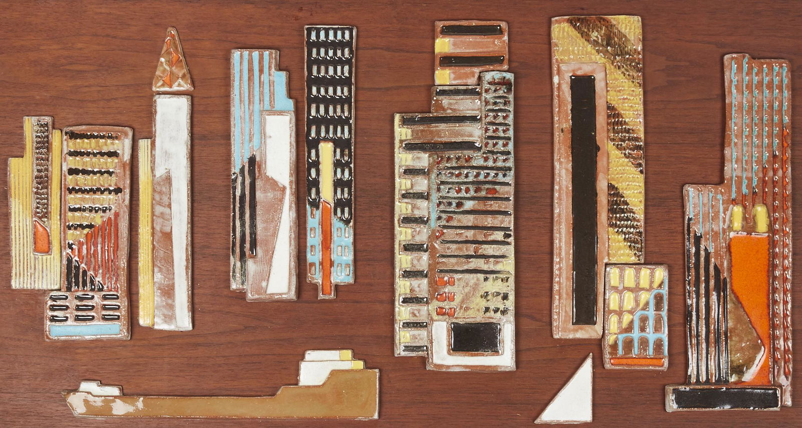 Large Harris Strong Studio "Cityscape" Ceramic Plaque: Harris Strong (1920-2006). Ceramic composition titled "Cityscape," made up of ten glazed ceramic tiles mounted on wood depicting an abstracted city scene. Height: 24 in x width: 48 in.
