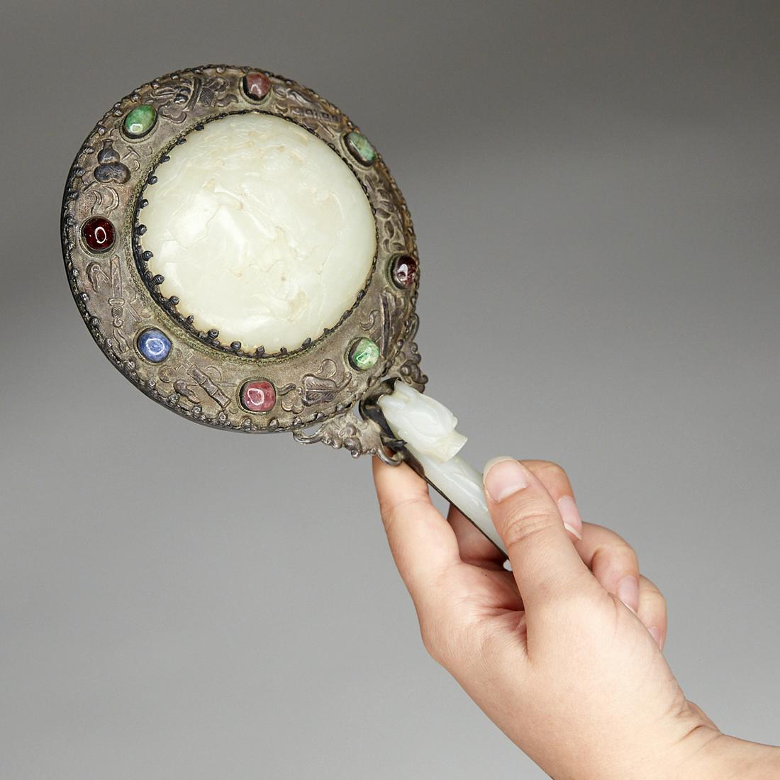 20th c. Chinese Jade Belt Hook and Silver Hand Mirror: 20th century Chinese silver and jade hand mirror. The delicately carved jade plaque along the back depicts an immortal among branches. The handle is made up of a celadon jade belt hook, and there are 