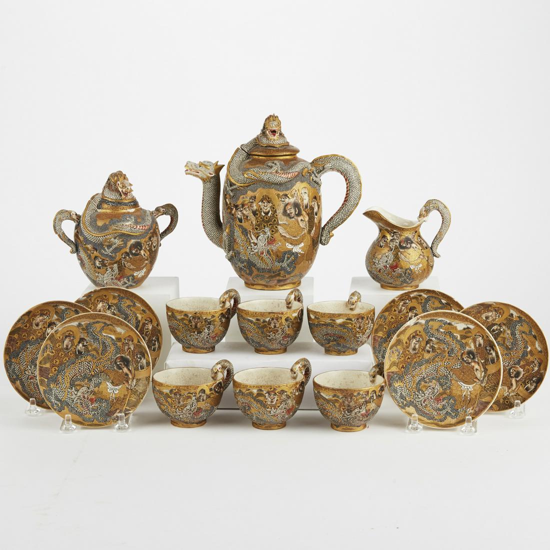 Japanese Meiji Satsuma Dragon Tea Set: Japanese satsuma tea set from the Meiji period profusely decorated with illustrated scenes and dragons in low relief. Comprised of one teapot, one creamer, one sugar bowl, and 6 teacups and saucers. E