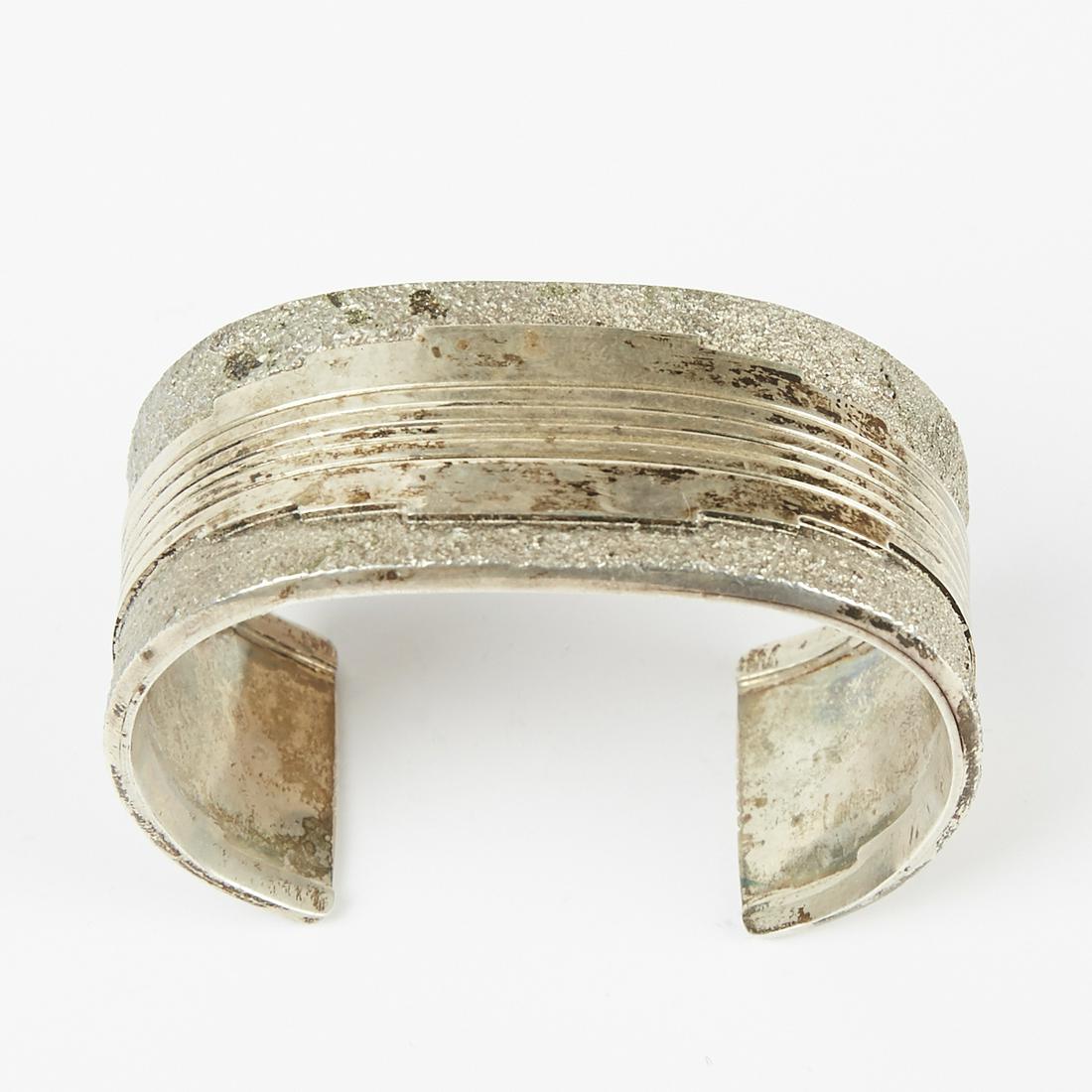 Gibson Nez Navajo Sterling Silver Bracelet: Southwestern sterling silver cuff bracelet with textured designs. Marked cZn along the interior. Possibly Navajo or Hopi. Height: 1 in x width: 2 1/2 in x depth: 1 3/4 in.; Weight: 2.59 troy oz.