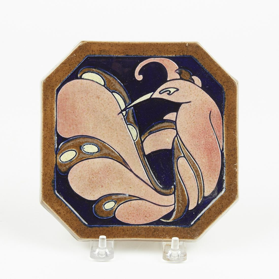 American Art Deco Pottery Carved Bird Trivet: American Art Deco pottery carved trivet or tile decorated with a glossy glaze and a stylized bird. Marked with artist's monogram along the underside. Height: 6 1/4 in x width: 6 1/4 in x depth: 1 in.