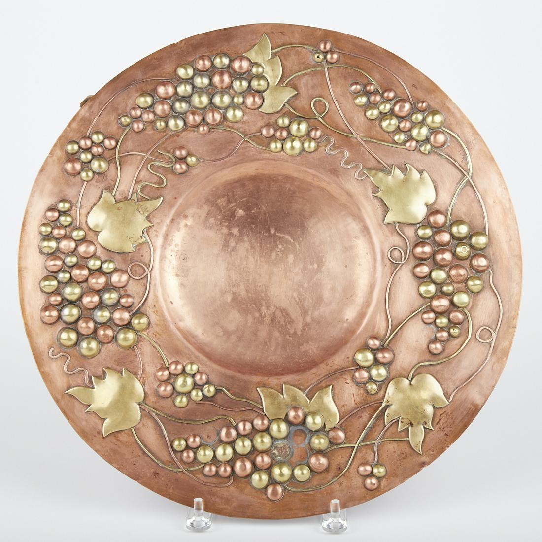 Minneapolis Handcraft Project WPA Mixed Metal Plaque: Minneapolis Handicraft Project hand wrought mixed metal hanging plaque, decorated with sprigs of grapes. Marked "Minneapolis Handcraft Project M-210" along the verso.Diameter: 16 1/8 in.