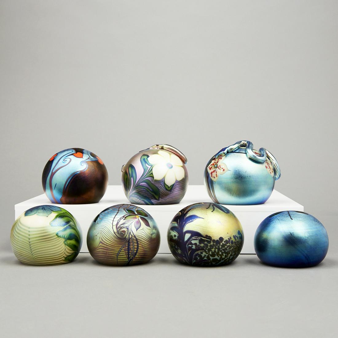 Grp: 7 Orient & Flume Favrile Glass Paperweights: Group of seven Orient & Flume favrile glass paperweights. All signed along the underside; five with the original stickers adhered to the underside.Height ranges from 2 in to 2 1/2 in; diameter ranges