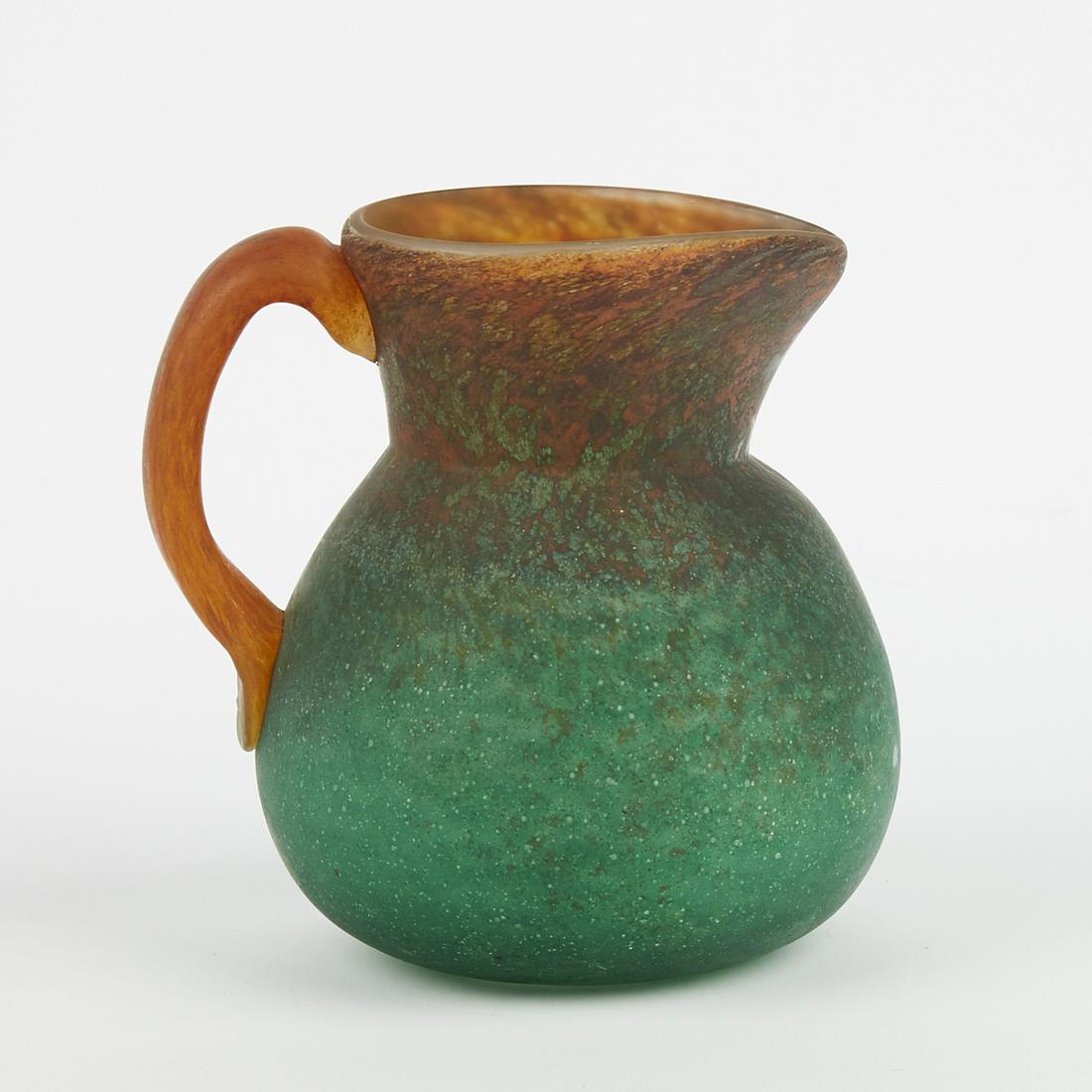 Georges de Feure Glass Pitcher: Georges de Feure (1868-1943). A late 19th-early 20th century pitcher with an orange to green color gradation. Signed along the underside.Height: 7 1/4 in x width: 5 1/2 in x depth: 7in.