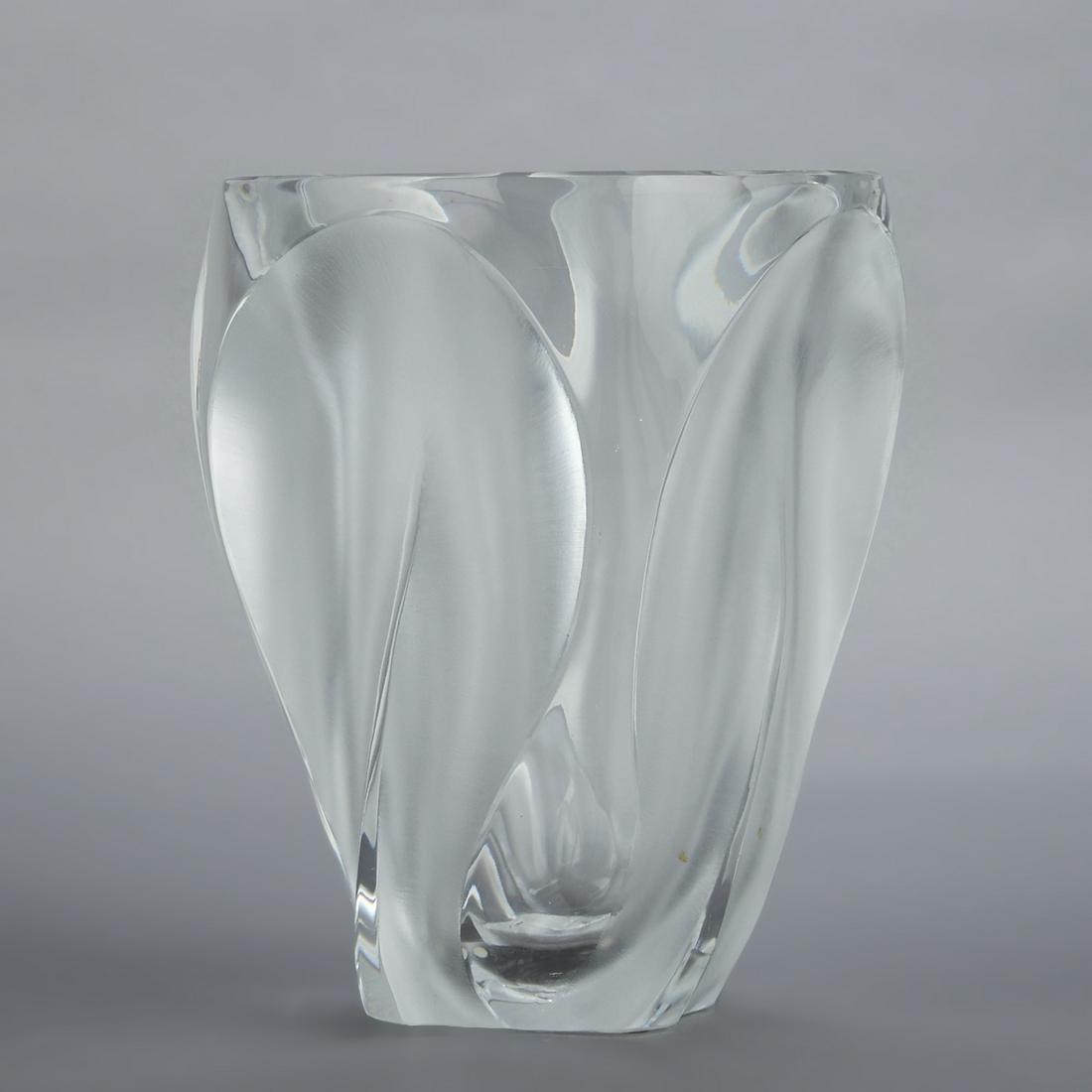 Lalique Ingrid Glass Crystal Vase: Lalique, France. A clear glass vase with frosted fluid curves along its sides making up its organic form. Marked "Lalique France" along the underside.Height: 10 1/2 in x diameter: 8 3/8 in.