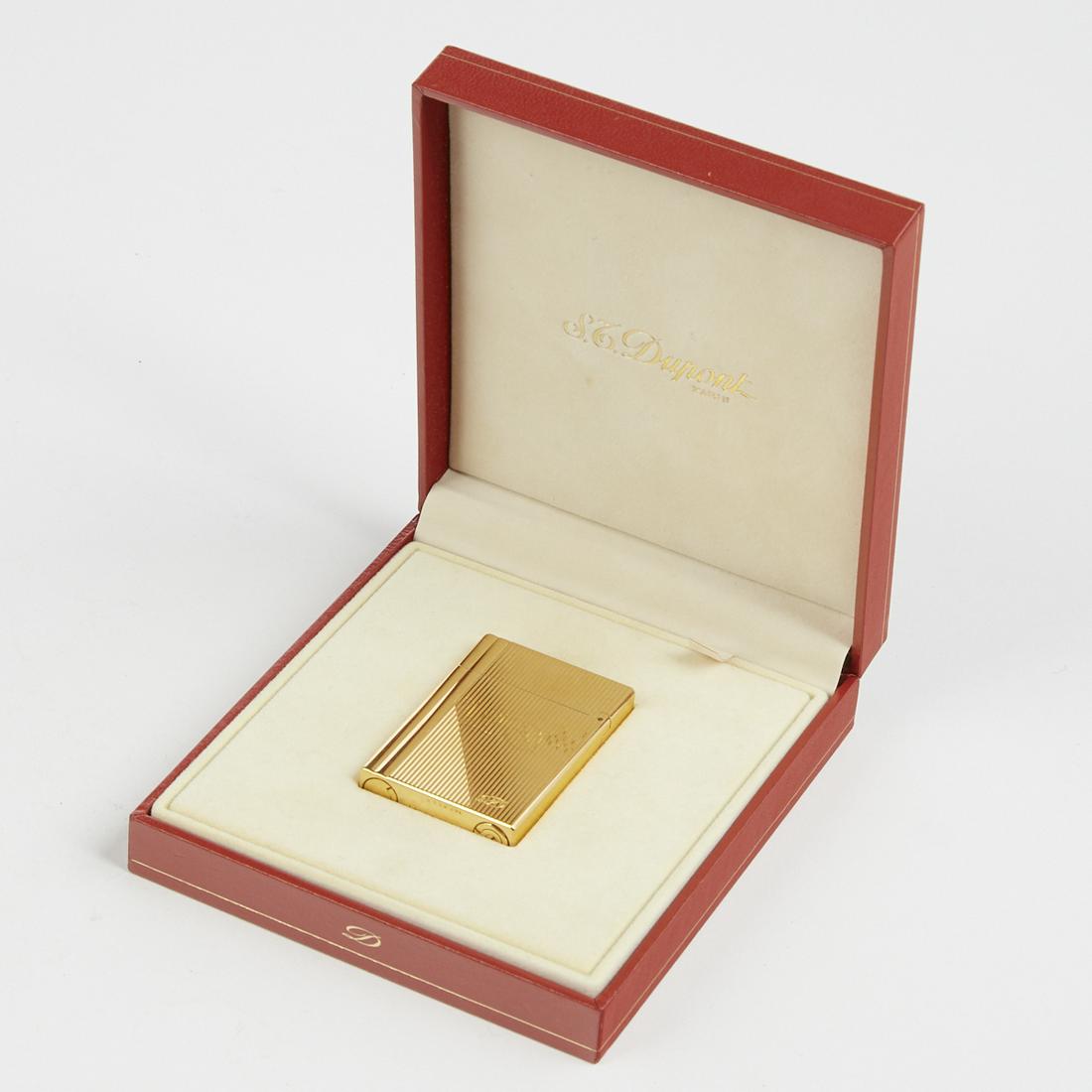 S.T. Dupont L1 Lighter With Box: S.T. Dupont, France. One gold plated Briquet De Poche L1 Plaque Argent Godrons Lat. & Lignes lighter in original presentation case and outer box. Impressed logo "S.T. Dupont" along the under