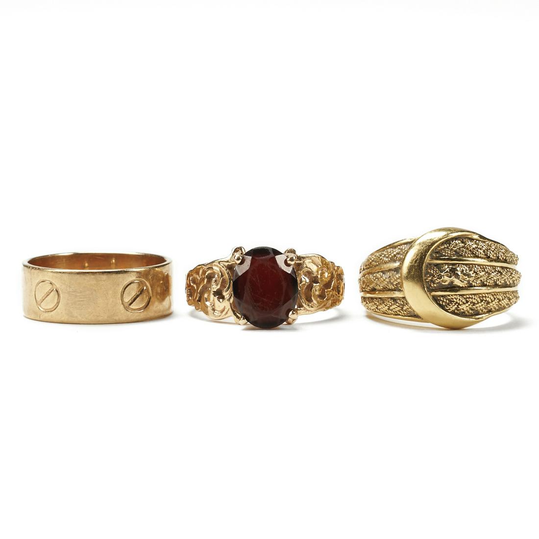 Grp: 3 Gold Rings - Garnet & Cartier Style: Group of three assorted rings, including one flat band with bold designs and five screw motifs and two stabilize beads imitating Cartier's "Love" ring, size 5 US, marked "14Kt" alo