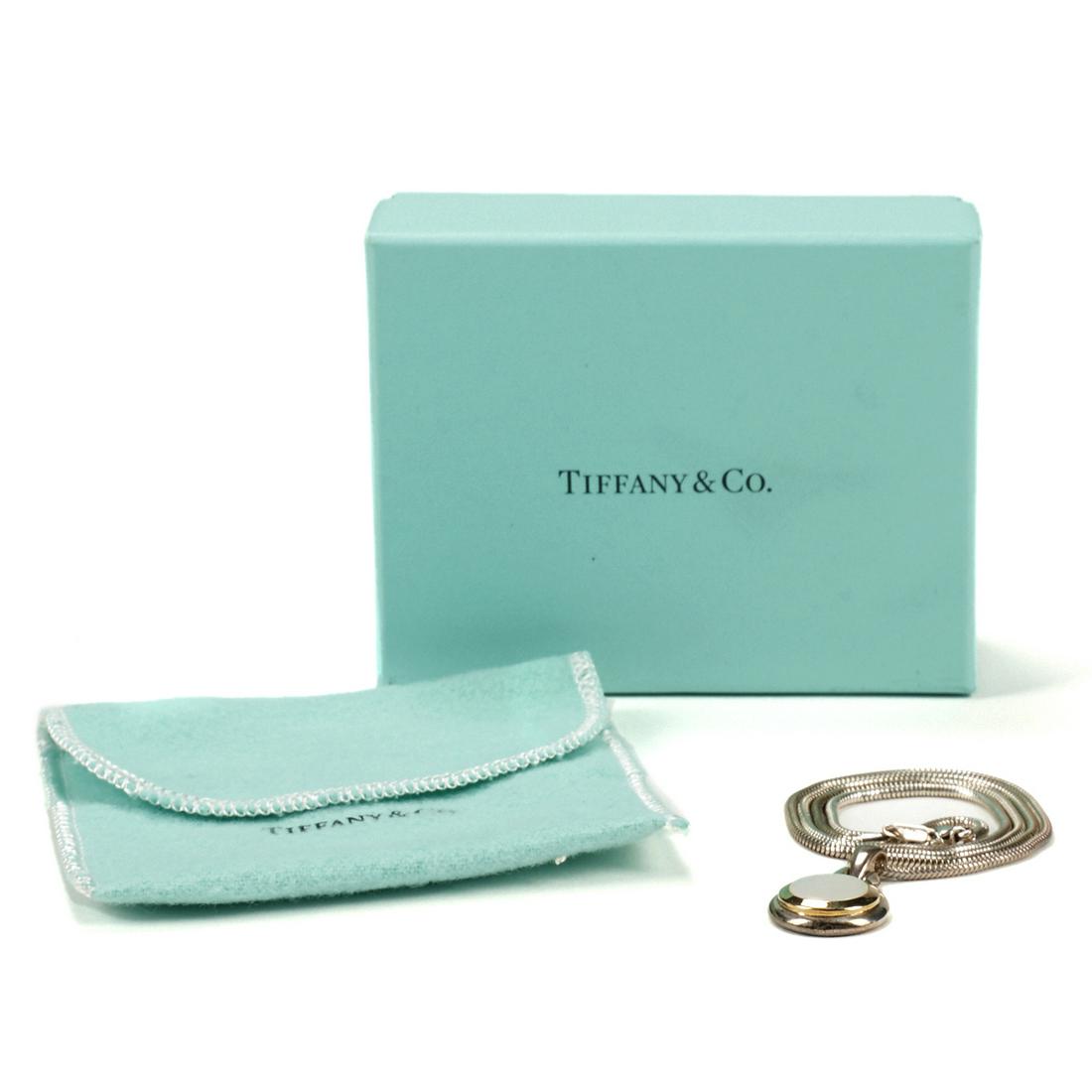 Tiffany Sterling Mother of Pearl Pendant Necklace: Tiffany & Co., New York, USA. Mother of pearl pendant necklace with a sterling silver snake chain and an 18K yellow gold accent around the pendant. Marked "Tiffany & Co. 1999 925 750" along