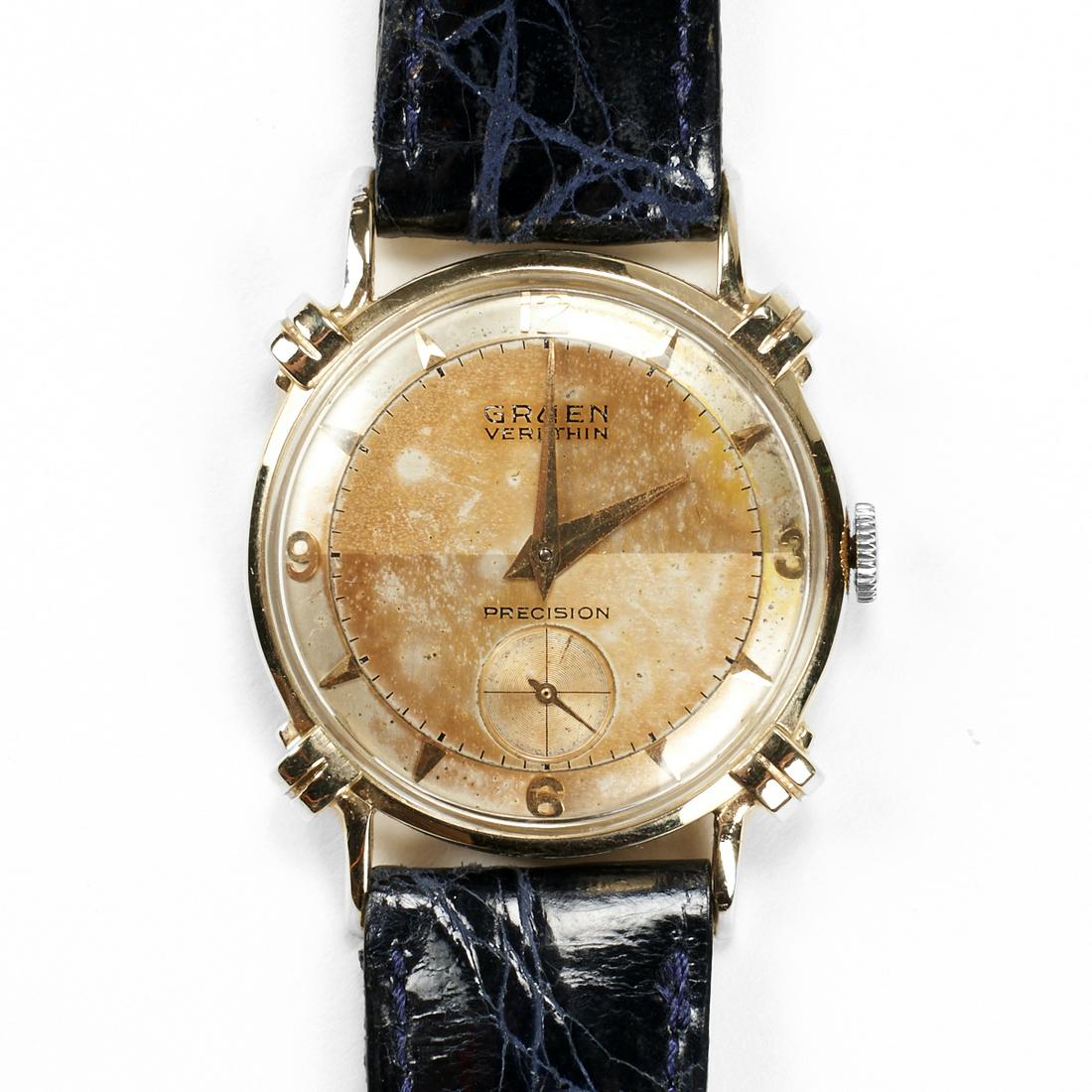 Gruen 14K Yellow Gold Veri Thin Wrist Watch: Gruen, United States. One mid-twentieth century Veri Thin manual wind wrist watch in 14 karat yellow gold on a dark blue leather strap with a tang buckle. The movement and crown works and is keeping t