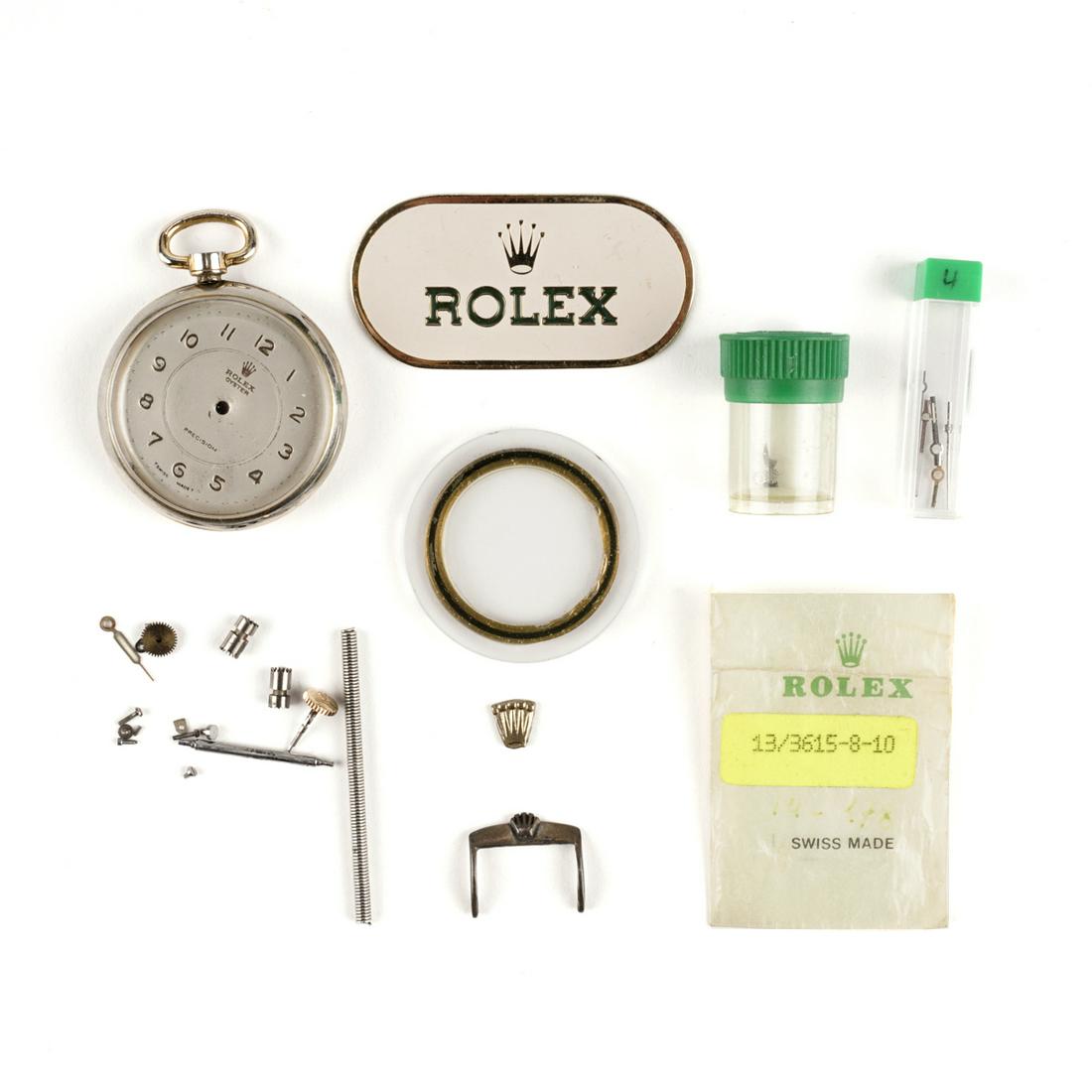 Grp: Rolex Watch Parts: Rolex, Switzerland. Group of assorted watch parts, including a pocket watch case with an impressed Rolex logo and crown; a dial with "Rolex Oyster Precision" applied to it; a buckle with a c