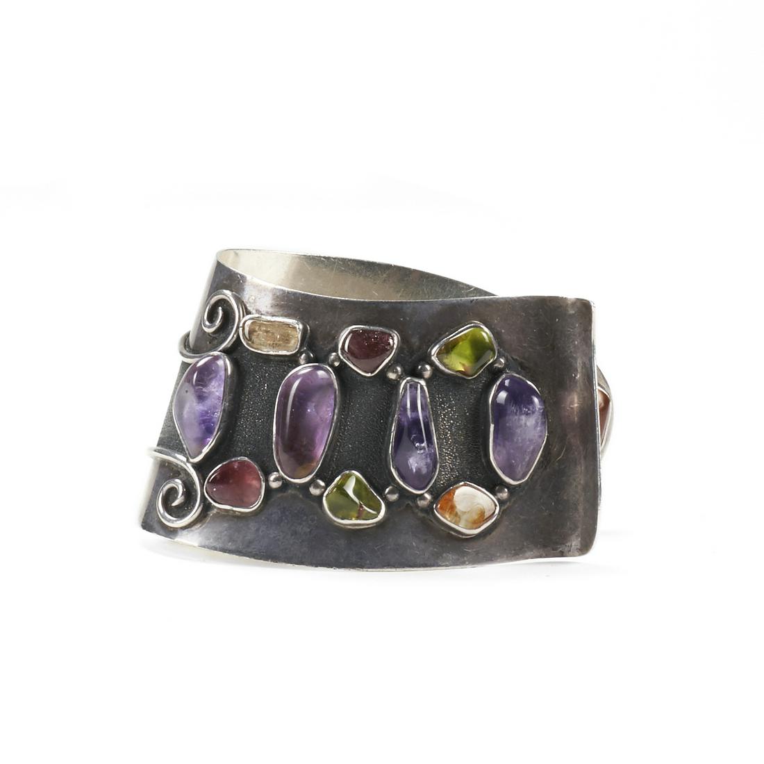 H. Fred Skaggs Silver & Colored Stone Cuff: H. Fred Skaggs (American, 1956-1983). One mid-twentieth century Modernist silver and colored stone cuff. It contains natural tumbled amethyst, rock crystal quartz, citrine, and peridot pebbles, all be