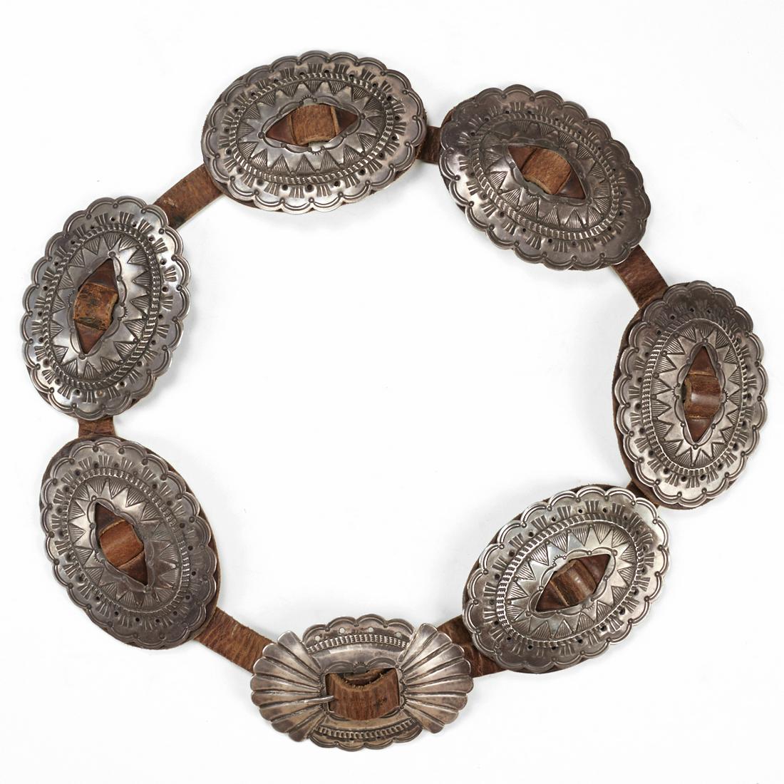 Navajo Silver Concha Belt Leather: One mid-twentieth century handmade Navajo Southwest Native American silver seven link concha belt on thin brown leather. Keywords: Concho Belt length: 40 3/4 in. Links length: 110 mm x width: 80 mm. S