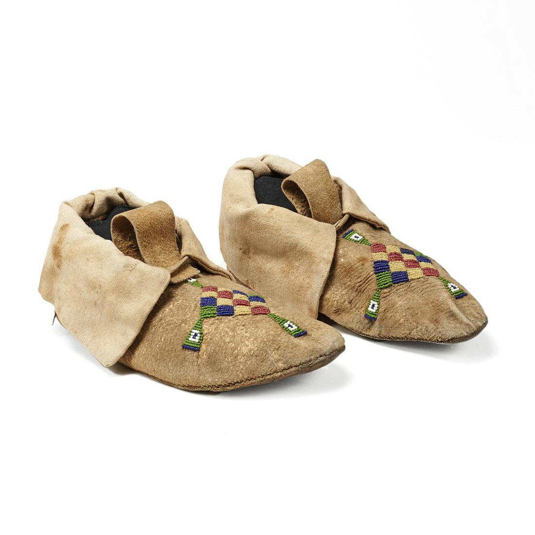 Pair of Plains Beaded Hide Moccasins Diamond: Pair of Native American Plains hide moccasins decorated with blue, red, green, yellow, and white beads in a diamond shaped pattern along the toes, ca. 1890-1910. Each; height: 4 in x width: 4 in x dep