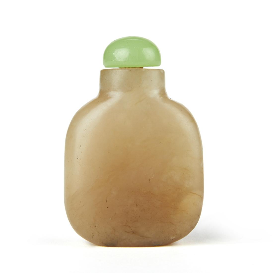Chinese Jade Snuff Bottle: Chinese jade snuff bottle in a rectangular shape with sloping shoulders and a white jade carved body and a vibrant green colored jade lid. Impressed oval mark along the underside. Height: 2 1/2 in x w