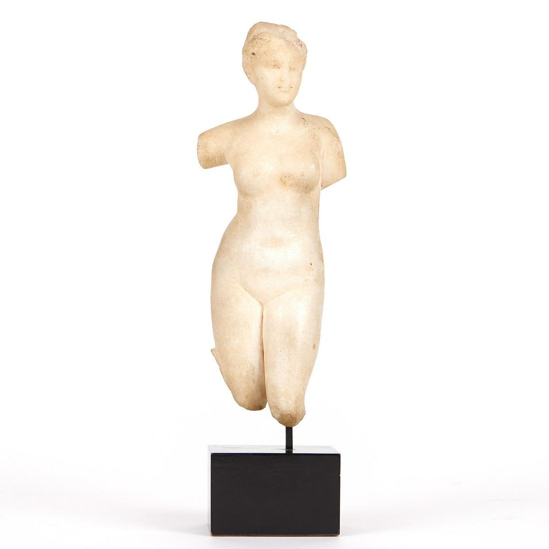 Classical Marble Figure of Venus: Small classical marble figure of a woman, likely the goddess Venus. She is depicted nude, her left leg placed slightly forward. Her fragmentary right arm is raised. Small figures of gods and goddesses