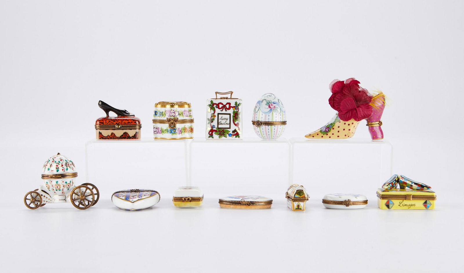 Grp: 12 Assorted French Limoges Porcelain Boxes: Limoges, France. Group of twelve assorted hand painted porcelain pill boxes. Shapes include: one large shoe; one small box with a black and white shoe affixed to the top that opens to reveal a second
